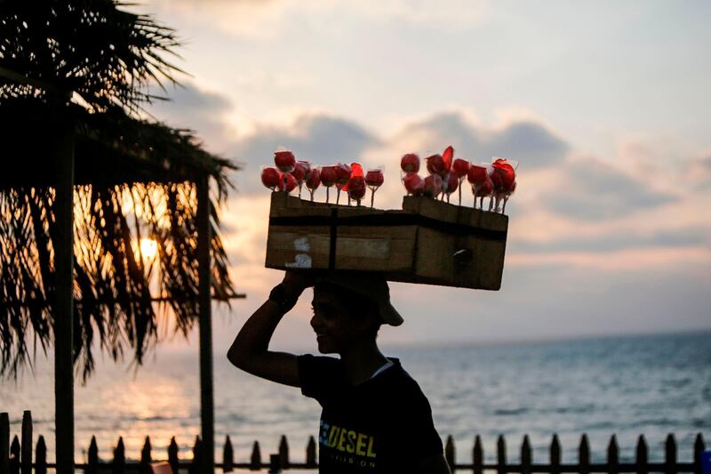 A Palestinian youth sells sweets by the beach in Gaza City as coronavirus restriction eases.  AFP