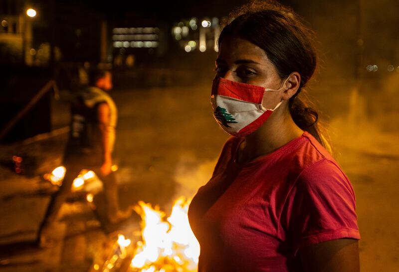 A protester wears a face mask with the Lebanese flag as anger over the country's economic crisis triggered fresh demonstrations on June 11, 2020.  EPA