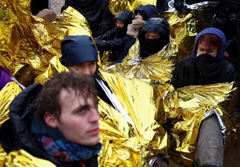 Activists stage a sit-in protest on a road. Reuters