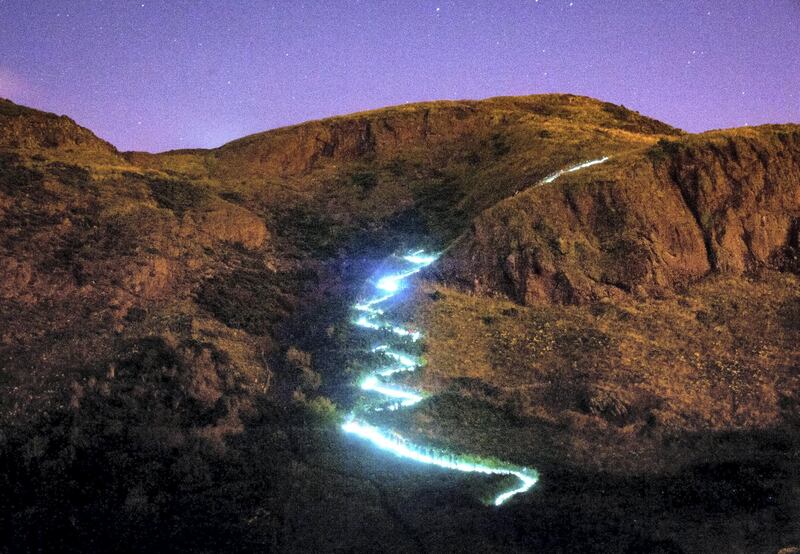 EDINBURGH, UNITED KINGDOM - AUGUST 09: The Edinburgh International Festival is launched with the Speed of Light, a choreographed public art piece on Arthur's Seat involving endurance runners and walkers using fluorescent lights, on August 9, 2012 in Edinburgh, Scotland. (Photo by Scott Campbell/Getty Images)