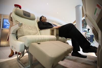 A man tests the recline on Emirates' new premium economy seats at the Emirates Airlines stand during the Arabian Travel Market fair in Dubai. EPA / Ali Haider