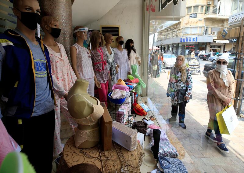 Women walk past a shop displaying mannequins wearing face masks in Sidon, southern Lebanon. Reuters