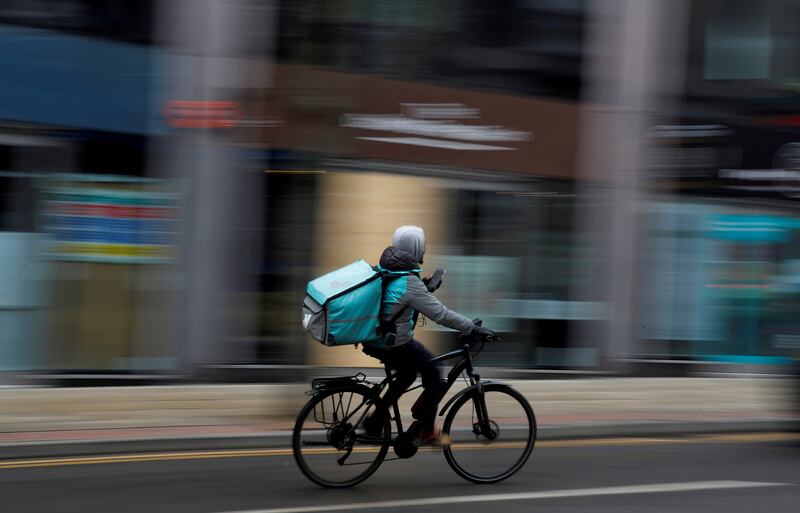 A Deliveroo delivery driver cycles through the centre of Manchester. Reuters