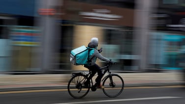 A Deliveroo delivery driver cycles through the centre of Manchester. Reuters