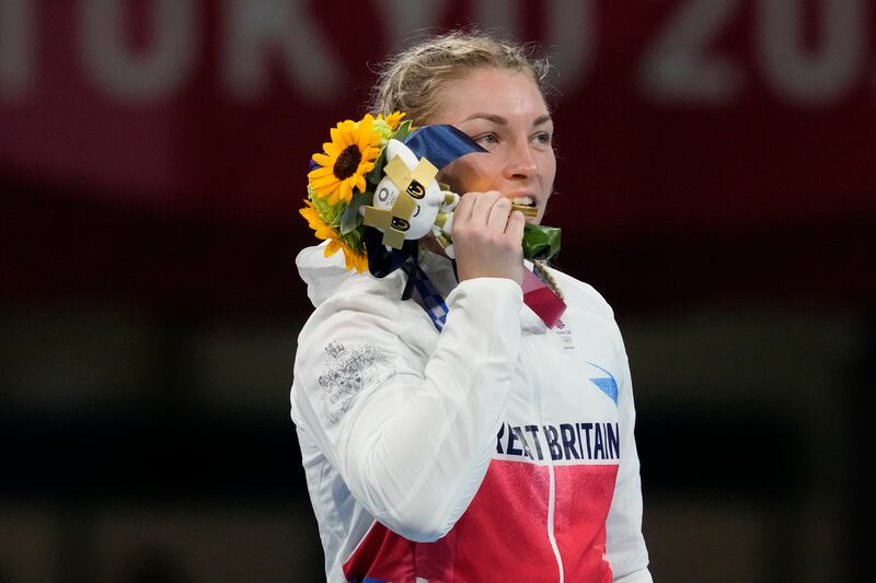 Gold medal winner Britain's Lauren Price bites the medal during their women's middleweight 75-kg boxing medal ceremony at the 2020 Summer Olympics.