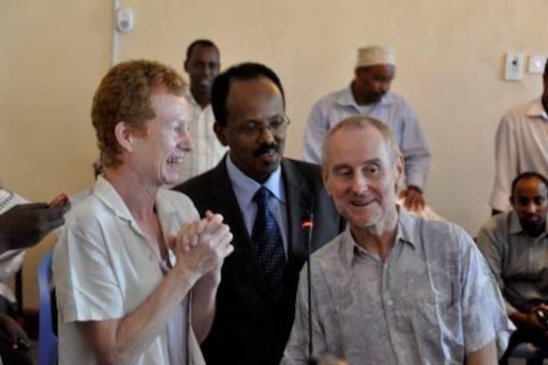 Released British hostages Rachel (L) and Paul (R) Chandler pose with newly-appointed Somali Prime Minister Mohamed Abdullahi Mohamed (C) on November 14, 2010 in Mogadishu. The released British couple flew from the town of Adado, where their 388-day ordeal came to an end earlier on November 14, to Mogadishu where they were greeted by top government officials. The Chandlers said they were "happy to be alive" after the Somali pirates who hijacked their yacht near the Seychelles last year released them for a ransom of 750,000 US dollars. From Mogadishu they were to fly to Nairobi's Wilson airport, where British officials were expected to take them to the high commission for a debriefing and medical treatment.           AFP PHOTO / MUSTAFA ABDI

 *** Local Caption ***  654718-01-08.jpg