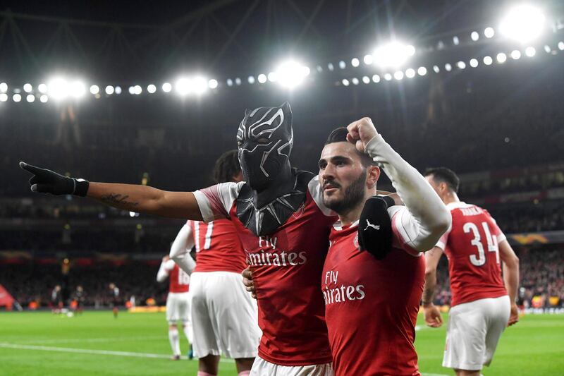 epa07437787 Arsenal's Pierre-Emerick Aubameyang (L) wears a mask as he celebrates scoring the 3-0 goal during the UEFA Europa League soccer match between Arsenal and Stade Rennes at the Emirates Stadium in London, Britain, 14 March 2019.  EPA/NEIL HALL