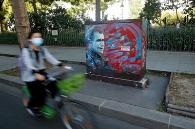epa08641145 A cyclist passes by a mural depicting police officer Ahmed Merabet who was shot dead by gunmen following the 07 January 2015 attack on Charlie Hebdo, on the opening day of the attacks trial, in Paris, France, 02 September 2020. The Charlie Hebdo terrorist attacks in Paris happened on 07 January 2015, with the storming of armed Islamist extremists of the satirical newspaper, starting three days of terror in the French capital.  EPA/YOAN VALAT