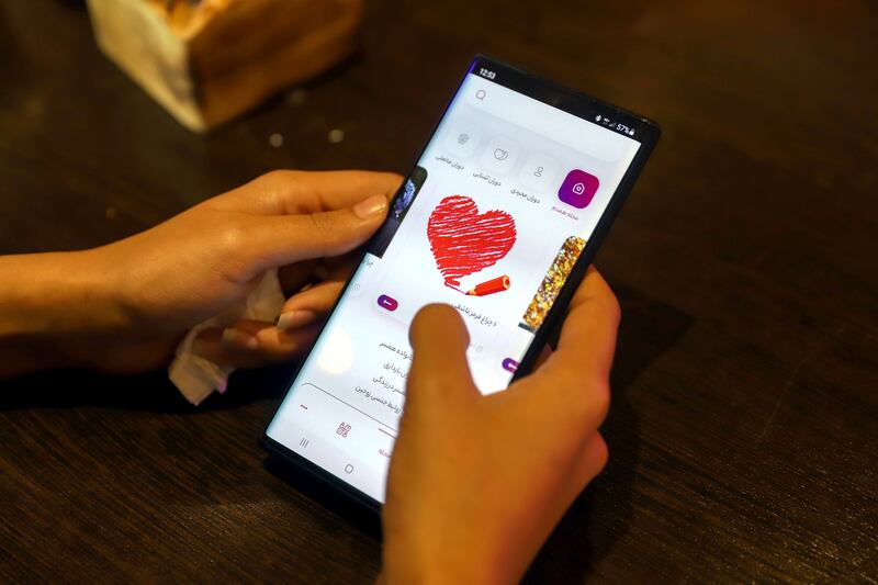 Iranian woman Atefeh Khani checks the "Hamdam" dating app on her phone in a cafe in Tehran, Iran. Reuters.