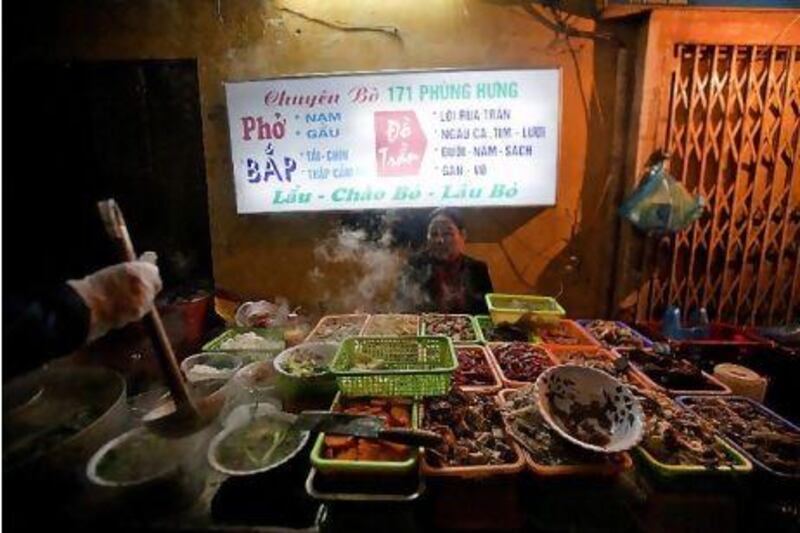 A street food vendor sells pho bo (an aromatic noodle soup) and various other dishes in Hanoi, Vietnam. The city offers a bewildering array of street food, from pancakes to sticky rice. Most offerings cost less than a few US dollars, and at Hang Dieu Street in the city's old quarter, travellers may sample local delicacies such as mien luon (noodles with eels, with ginger and lemon) or che, a rice pudding that is served cold. Justin Mott / Bloomberg