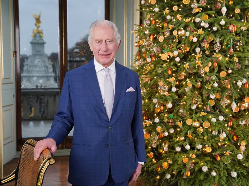 King Charles delivering his Christmas address from Buckingham Palace, with the Queen Victoria Memorial behind him. PA