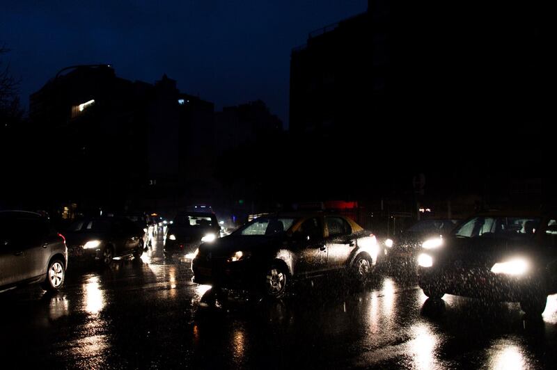 Cars drive through an unlit street during a blackout in Buenos Aires, Argentina.  AP