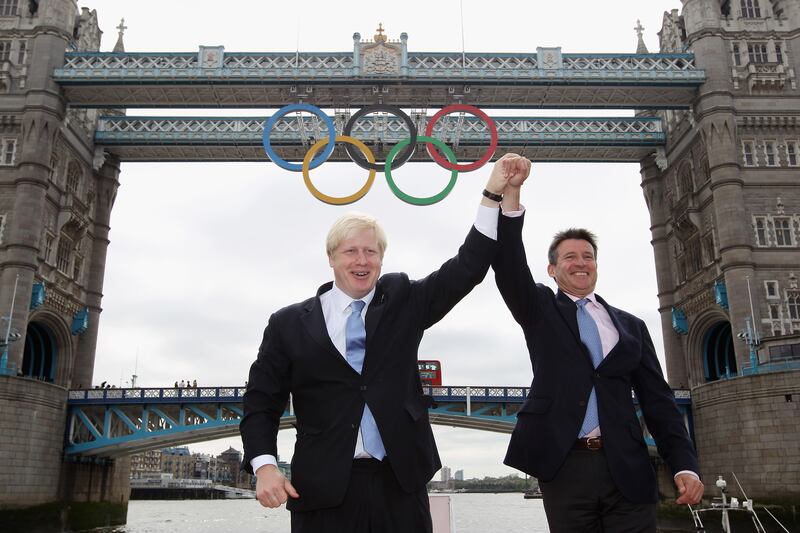 Mr Johnson and Lord Sebastian Coe cheer as a giant set of Olympic rings is displayed from Tower Bridge in June 2012, Getty Images