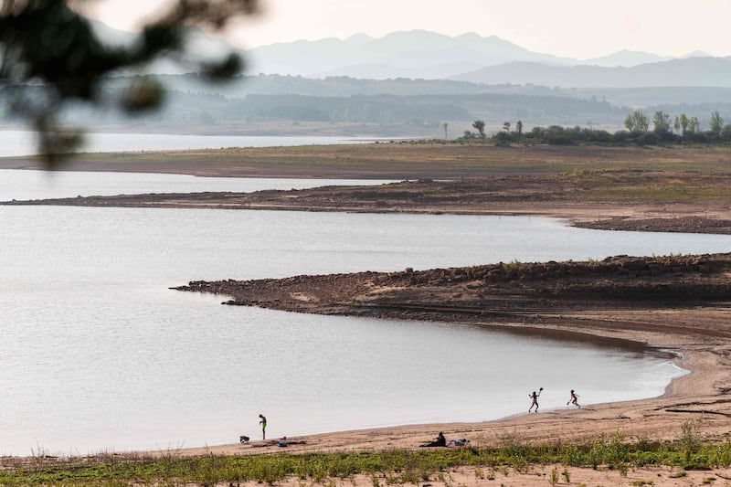 People play in the shore of the Aguilar de Campoo reservoir in Spain. AFP