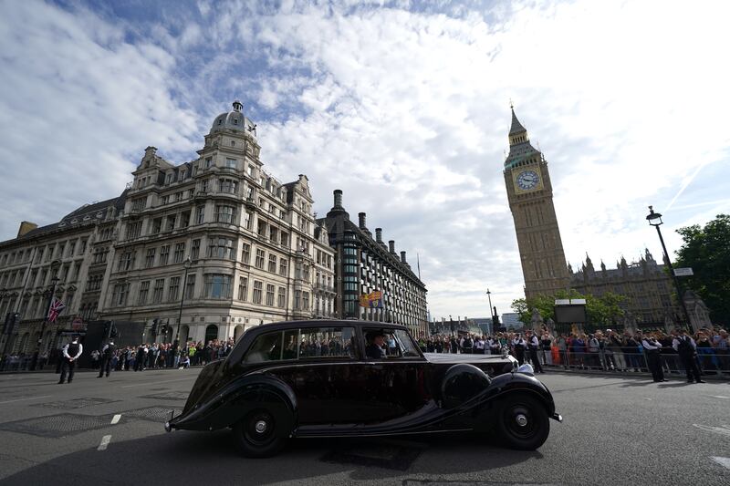 The king and the queen consort pass Big Ben en route to Westminster Hall. PA