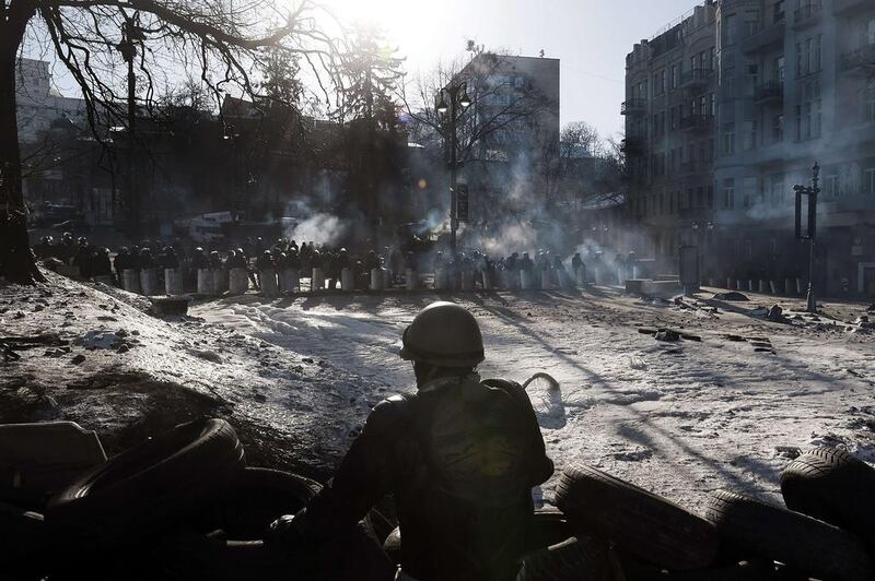 Riot police stand guard opposite anti-government protesters at a roadblock in Kiev on February 3, 2014. Tens of thousands of protesters rallied in Ukraine on Sunday in a bid to wring new concessions from President Viktor Yanukovich, buoyed by pledges of support from Europe and the United States. More than 50,000 people could be seen on Kiev’s barricaded Independence Square, which has become the epicentre of a two-month protest movement. Aris Messinis / AFP photo