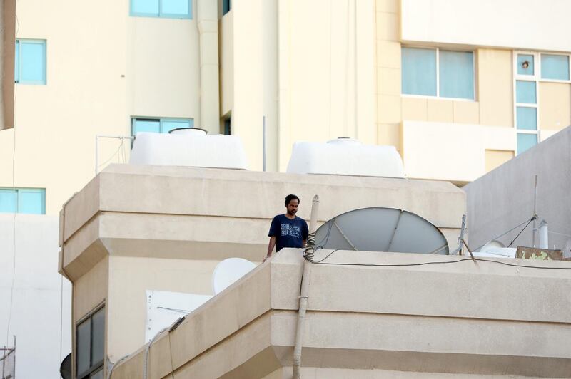 DUBAI, UNITED ARAB EMIRATES , April 27 – 2020 :- A resident looking at the streets from his home in Al Ras area in Deira Dubai. Authorities ease the restriction for the residents after almost a month long locked down of Al Ras district. (Pawan Singh / The National) For News/Standalone/Online/Instagram