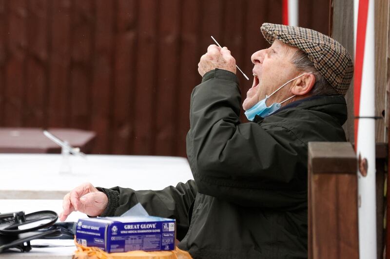 A man swabs the back of his throat at a mobile testing site at the Bramley Inn in the village of Bramley, west of London. AFP