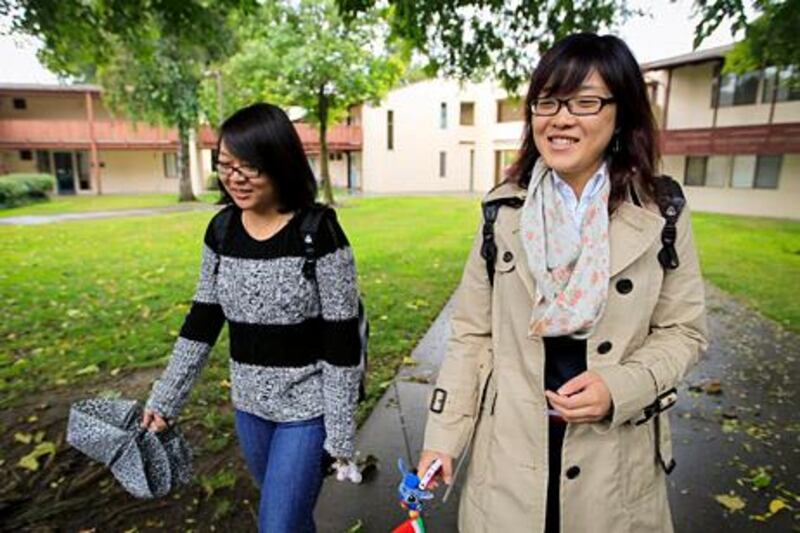 University of California freshmen Guan Wang, right, and Tracy Chen walk to class in Davis, California, U.S., on Monday, Oct. 10, 2011. Seeking the world's best education, Wang's parents in northeast China paid an agency there $4,700 to get her into a premier American boarding school in 2009. Boarding schools with small endowments and less selective admissions policies are boosting their revenue and enrollment by recruiting thousands of Chinese students who pay full freight. Photographer: Tony Avelar/Bloomberg *** Local Caption *** Guan Wang; Tracy Chen