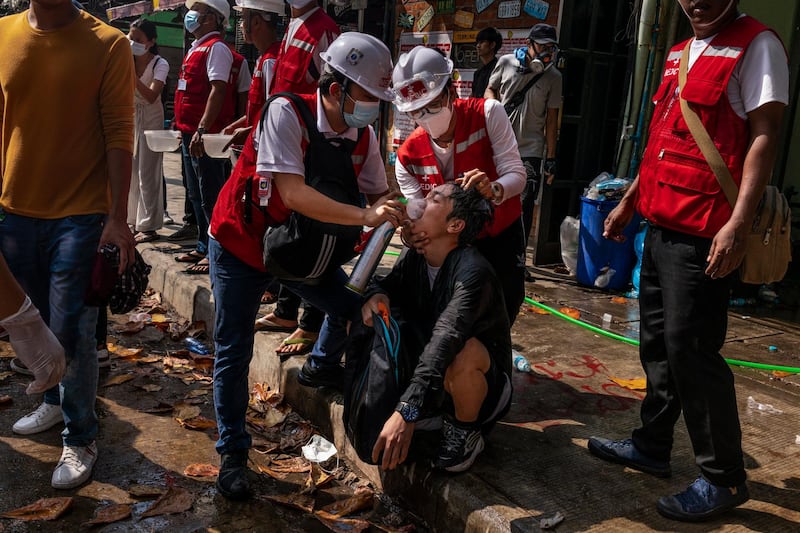 Medics give oxygen to anti-coup protesters who faced tear gas during clashes in Yangon, Myanmar. Getty