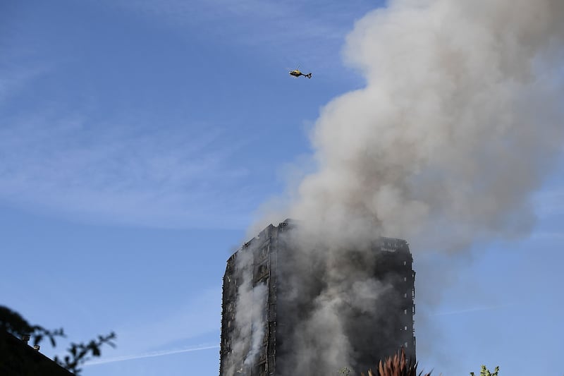 A helicopter circles as smoke rises from the building. Getty Images