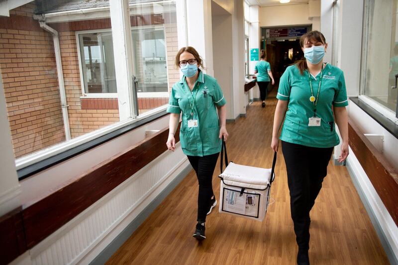 Pharmacists transport a cooler containing the Moderna vaccine at the Glangwili General Hospital in Carmarthen, Wales. Reuters