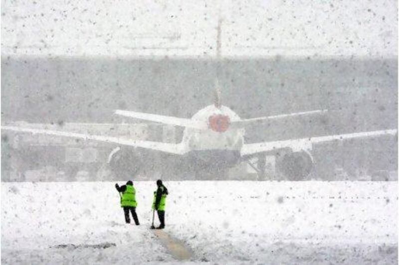 Good luck with that: workers try to clear the snow at London's Heathrow Airport, after all flights at the airport were grounded yesterday.
Steve Parsons / PA / AP