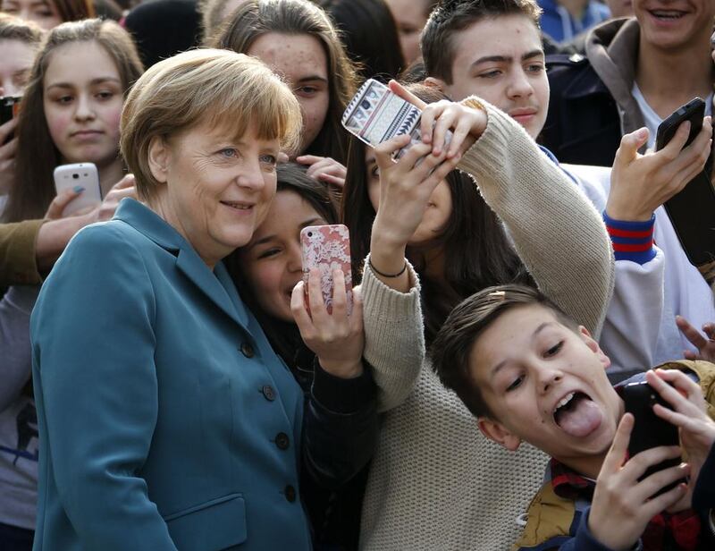 Pupils take mobile phone ‘selfies’ with German Chancellor Angela Merkel, as she arrives for a visit at Robert-Jungk Europe high school as part of the Europe-Project Day, in Berlin. Fabrizio Bensch /Reuters