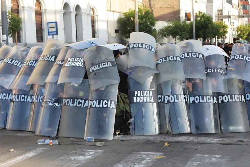 Police take cover during a demonstration against the government of Peruvian President Dina Boluarte in Lima. AFP
