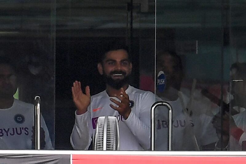 India captain Virat Kohli applauds in the dressing room after teammate Umesh Yadav hits a six. AFP