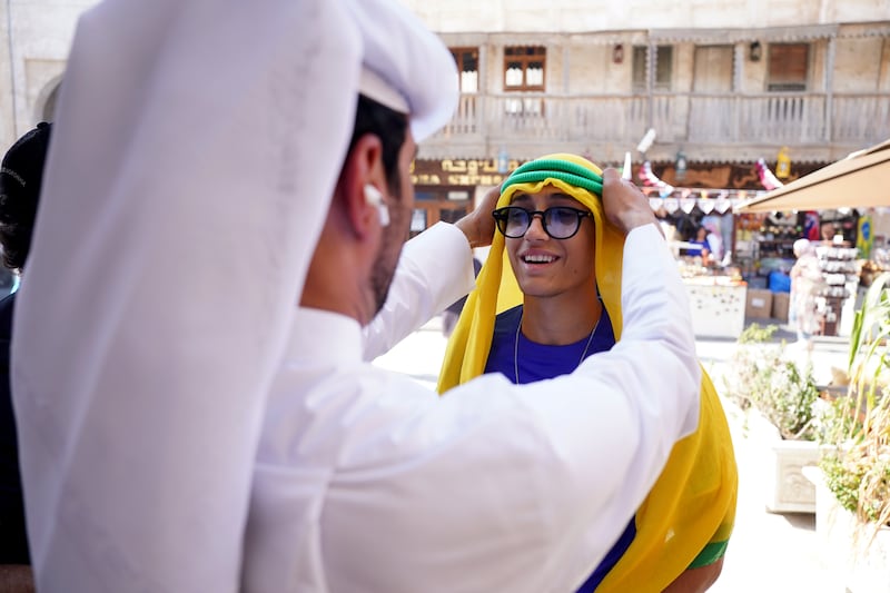 Supporters have been kitted out with themed ghutras in the Souq area of Doha. PA