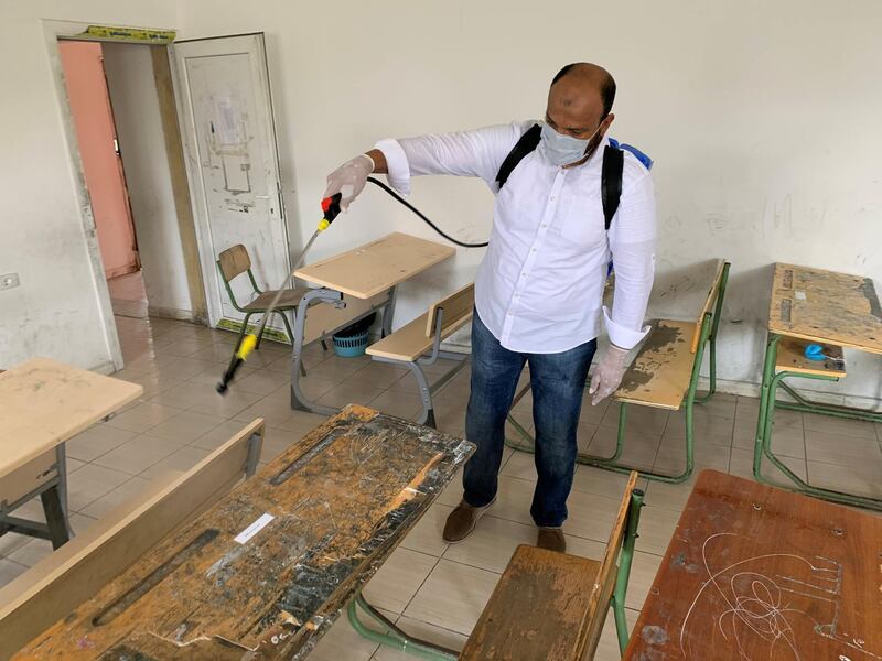 A teacher sprays disinfectant to sanitize a classroom after some schools reopened amid the coronavirus disease (COVID-19) crisis, in Misrata, Libya. REUTERS