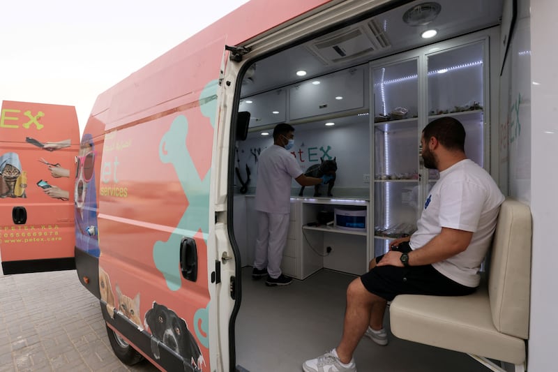 A pet owner sits as his dog is attended to by a mobile pet-grooming service in Riyadh, Saudi Arabia. Reuters