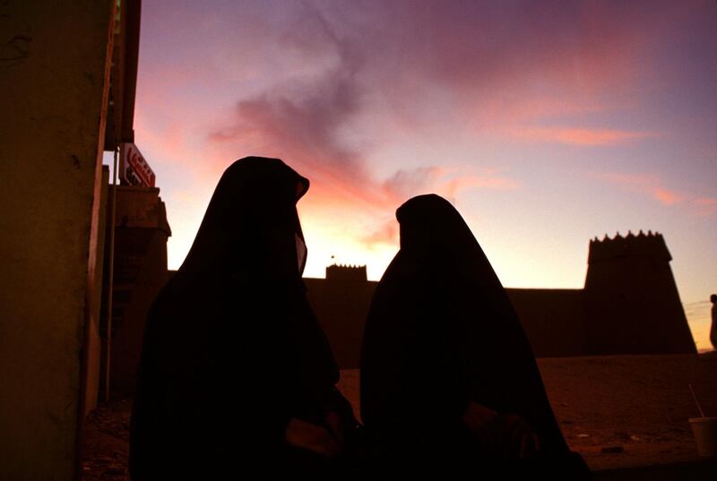 B0HND5 A silhouette of women wearing burqas outside a building, Saudi Arabia.