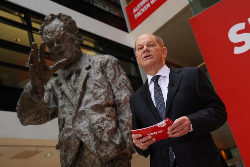 German Chancellor Olaf Scholz gives a speech next to a statue of Cold War leader Willy Brandt, whose peacemaking efforts shaped the outlook of much of Mr Scholz's generation. Getty Images