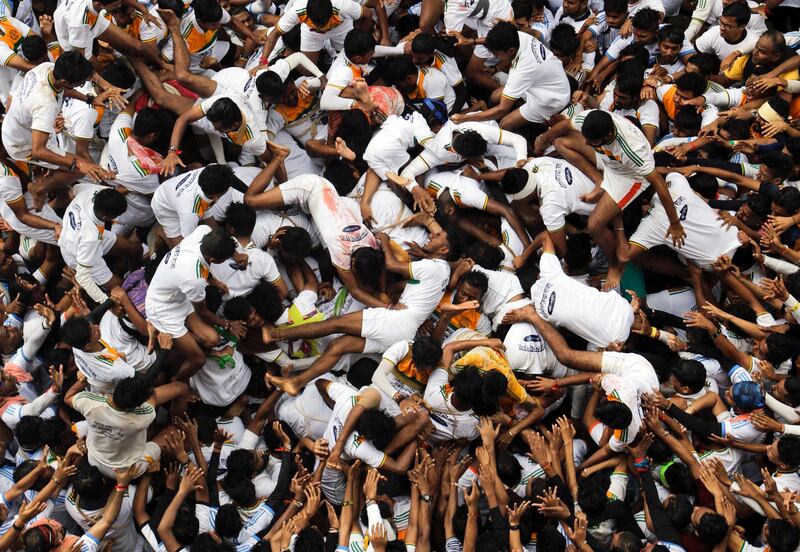 Indian youth  try to form a human pyramid to break the "Dahi handi," an earthen pot filled with curd hanging above them, as part of celebrations to mark the Janmashtami festival in Mumbai. Rajanish Kakade / Reuters