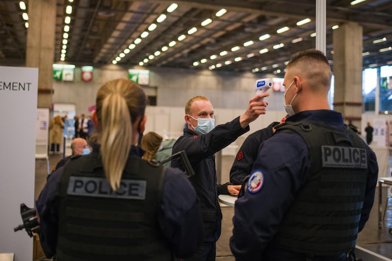Police officers have their temperatures taken as they arrive at the 'vaccinodrome' vaccination site at the Porte de Versailles exhibition center in Paris, France. Bloomberg