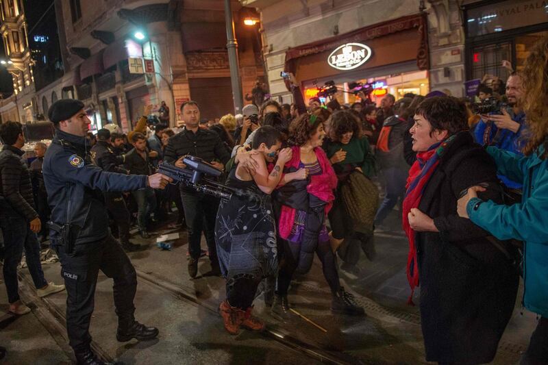 A Turkish riot police officer uses a non-lethal hand-held weapon during clashes. AFP