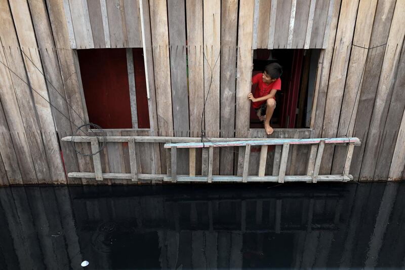 A boy looks outside of his window above a street flooded by the overflowing Negro River in Sao Jorge neighborhood in Manaus, Amazonas state, Brazil. Reuters