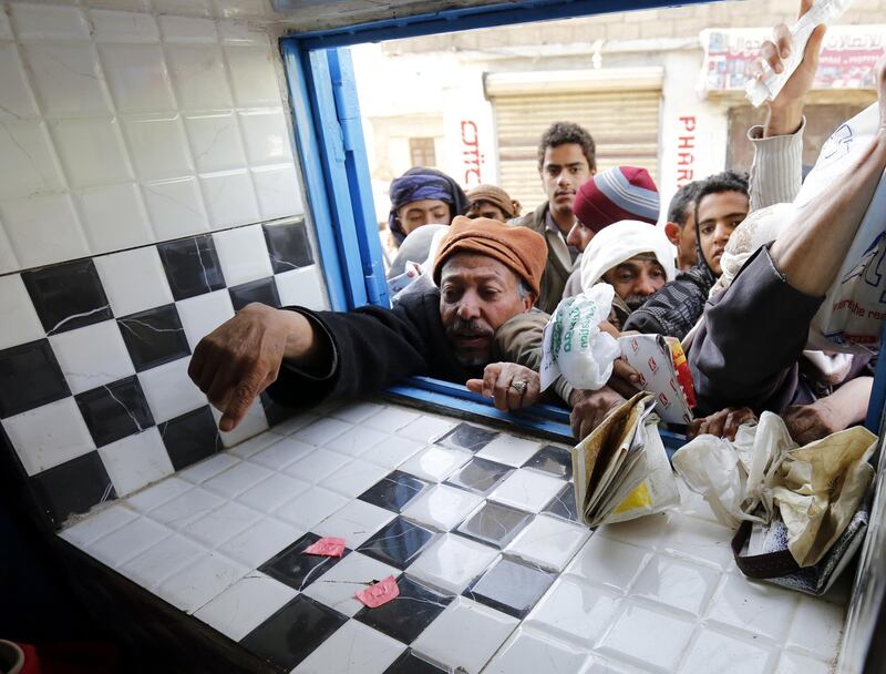 Yemenis gather to receive free bread in Sana'a, Yemen. EPA