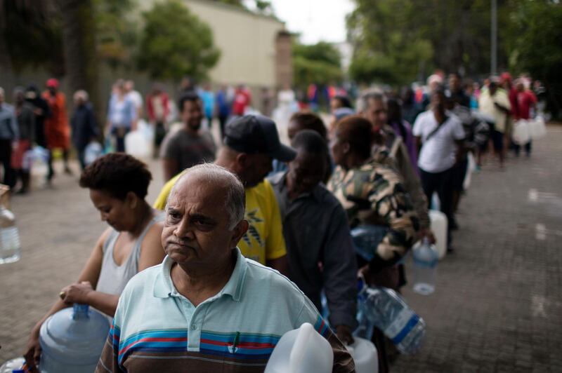 Residents queue to fill containers with water from a source of natural spring water in Cape Town, South Africa, Friday, Feb. 2, 2018. South Africa's drought-hit city of Cape Town introduced new water restrictions in an attempt to avoid what it calls "Day Zero," the day in mid-April when it might have to turn off most taps. (AP Photo/Bram Janssen)