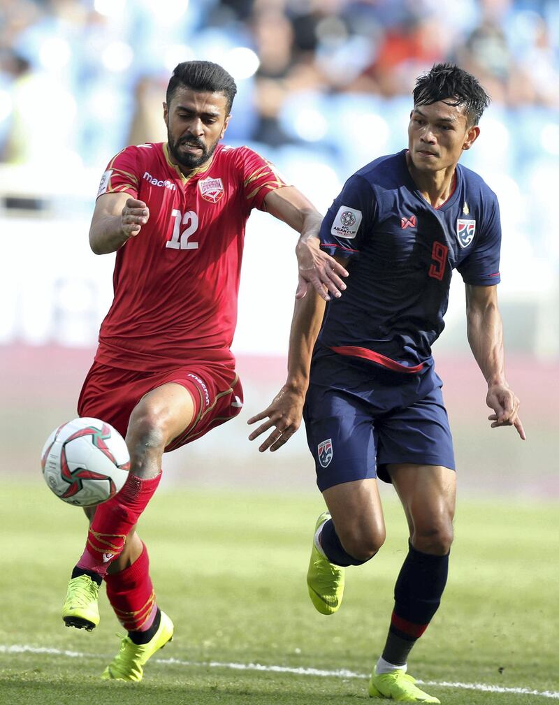 Dubai, United Arab Emirates - January 10, 2019: Ahmed Ali Juma of Bahrain and Adisak Kraisorn of Thailand battle during the game between Bahrain and Thailand in the Asian Cup 2019. Thursday, January 10th, 2019 at Al Maktoum Stadium, Abu Dhabi. Chris Whiteoak/The National