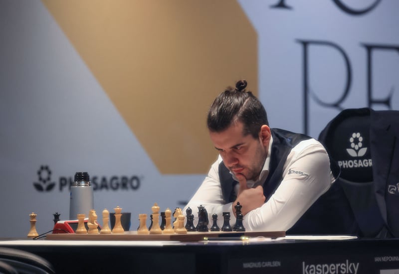 Russian chessmaster Ian Nepomniachtchi competes against Norwegian chessmaster Magnus Carlsen (unseen) during Game 2 of the FIDE World Chess Championship at Expo 2020 Dubai. AFP