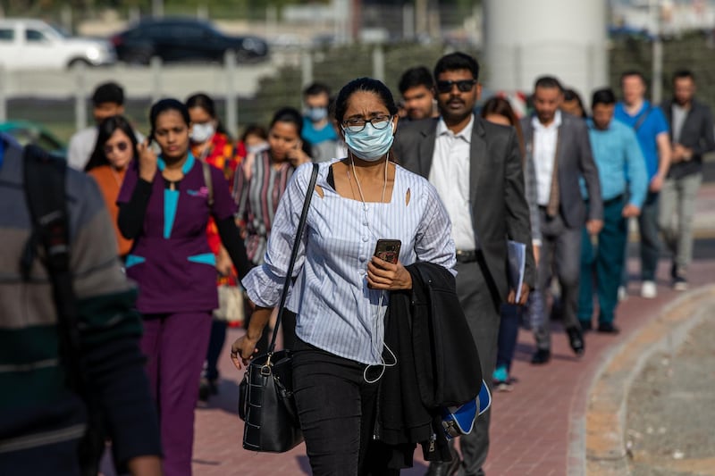 A commuter, wearing a protective face mask, walks in Downtown Dubai on March 5. Bloomberg