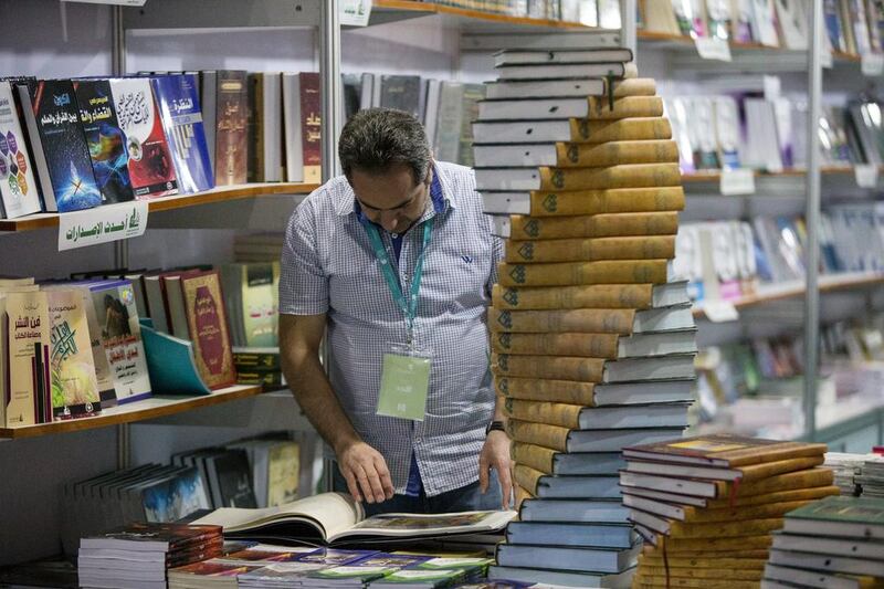 A man glances at a book at the fair.