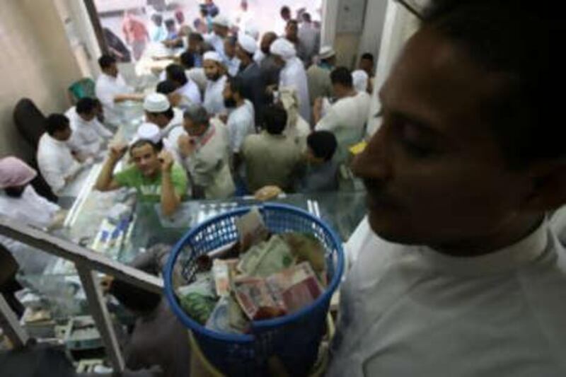 A Man holds baskets filled with foreign currencies to take it to the 1st floor of a money exchanging store as Muslim pilgrims exchange different currencies to Saudi riyal in Mecca.