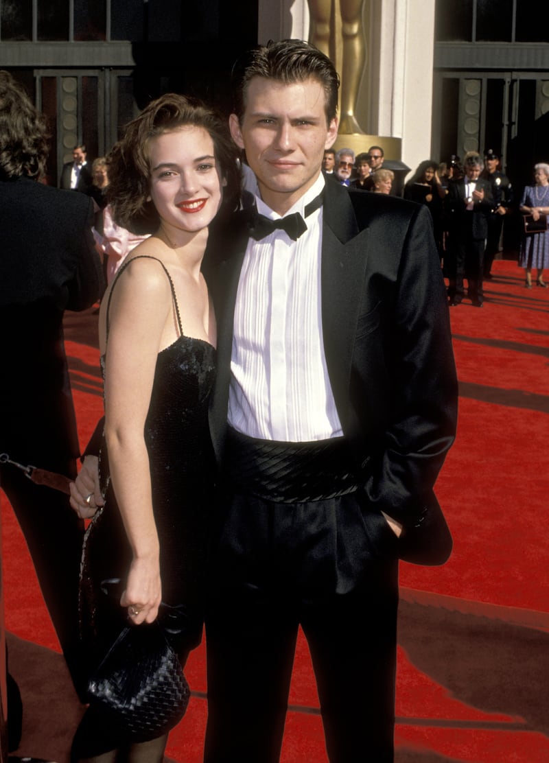 Winona Ryder, accompanied by  Christian Slater, wears a classic strappy black dress at the Shrine Auditorium for the 61st Annual Academy Awards in Los Angeles, California on March 29, 1989. Getty