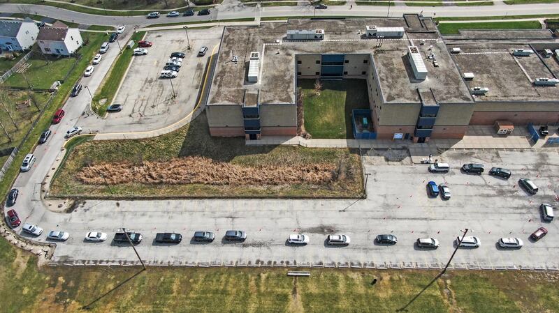 An aerial photo shows people in vehicles lined up to receive iPads and Chromebook laptop computers for students to use in remote learning at Indian Hills Elementary School in Round Lake Heights, Illinois.  EPA