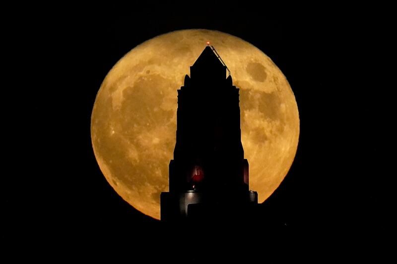 The art deco spire of the Power and Light building in  Kansas City is silhouetted against a supermoon. AP