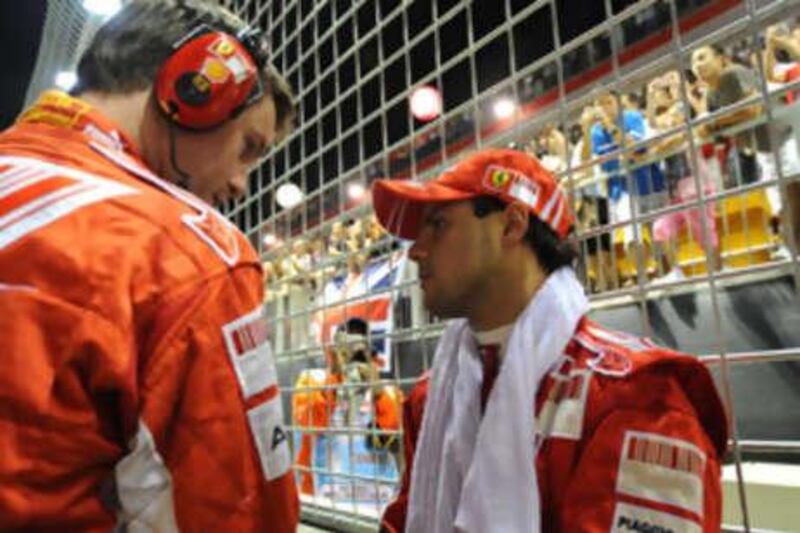 Felipe Massa of Ferrari, right, looks dejected after retiring from the Singapore Grand Prix.